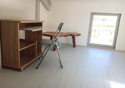 een bureau en een stoel in een kamer met een raam bij le Refuge d'Eugénie in Bahus-Soubiran