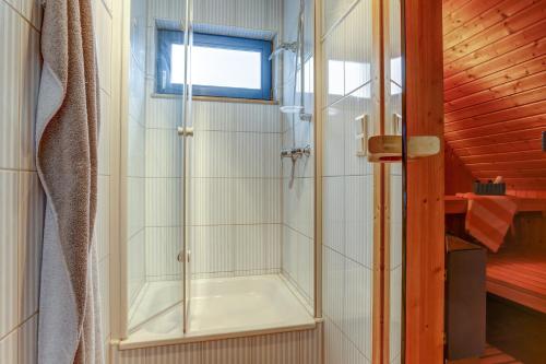 een douche met een glazen deur in de badkamer bij Meeresrauschen 1 in Groß Kirr
