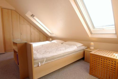 ein Schlafzimmer mit einem Bett in einem Zimmer mit einem Dachfenster in der Unterkunft Residenz am Strand Wohnung 3-54 in Zingst