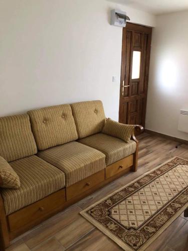 a brown couch in a living room with a rug at Nagymama Vendégháza in Telkibánya