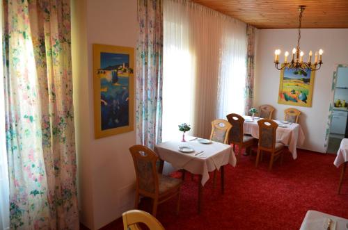 ein Esszimmer mit einem Tisch, Stühlen und einem Fenster in der Unterkunft Hotel Drei Schweizer in Neuwied