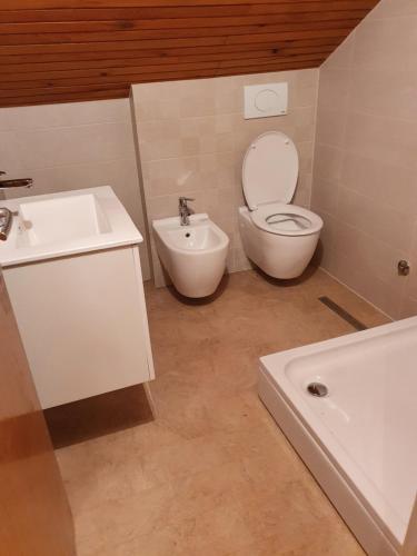 a bathroom with a toilet and a sink and a tub at Peaceful Vacation Villa & Garden in Sarajevo