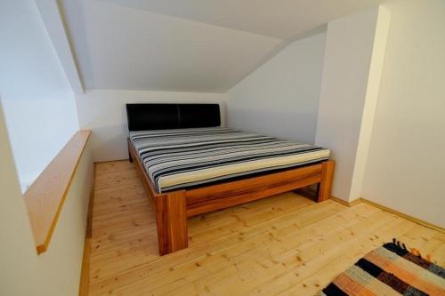 małe łóżko w małym pokoju z drewnianą podłogą w obiekcie Apartment in Kali with Seaview, Terrace, Air condition, WIFI (4672-2) w mieście Kali
