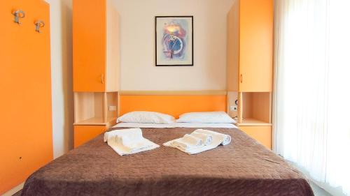 ein Schlafzimmer mit einem Bett mit zwei Handtüchern darauf in der Unterkunft Hotel Esperia in Caorle