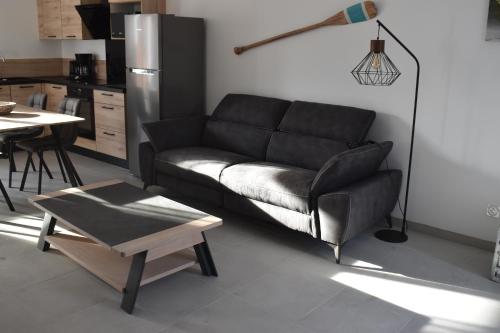 un salon avec un canapé et une table dans l'établissement RESIDENCE LE GALLION, à Lacanau-Océan