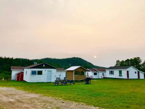 a row of houses with a picnic table in a field at Bonne Bay Cottages in Bonne Bay Pond
