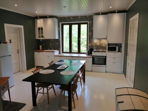 une cuisine avec une table et des chaises. dans l'établissement Guesthouse Lokinlaulu, à Kotka