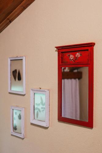 a red mirror hanging on a wall with pictures at Villa Polytimi in Vonitsa