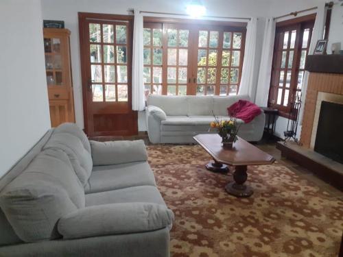 a living room with a couch and a coffee table at Casa no Capivari in Campos do Jordão