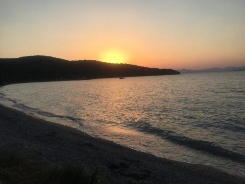 a sunset over a body of water with a beach at Villa Polytimi in Vonitsa