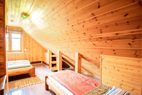 Ce chalet en rondins comprend un lit dans une chambre. dans l'établissement Pas Kaziuką namas-sodyba, à Ignalina