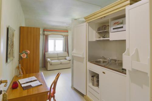 a kitchen and dining room with a table and a couch at Park Hotel Villa Salzea in Trofarello