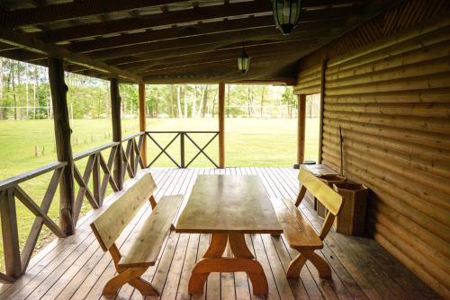 una mesa de madera y 2 sillas en el porche en Pas Kaziuką namas-sodyba en Ignalina