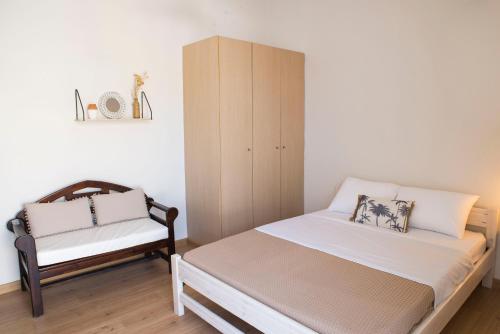 Un pequeño dormitorio con una cama y una silla. en CASA CUORE Quiet and authentic near the sea, en Káto Ássos