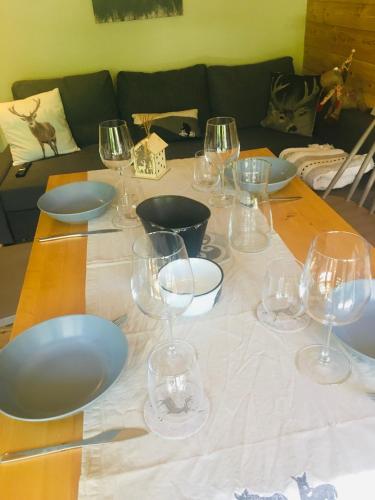a table with wine glasses and bowls on it at Ambiance petit chalet in La Salle Les Alpes