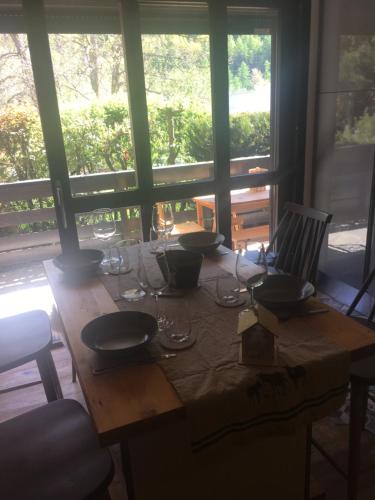 a wooden table with wine glasses on top of it at Ambiance petit chalet in La Salle Les Alpes