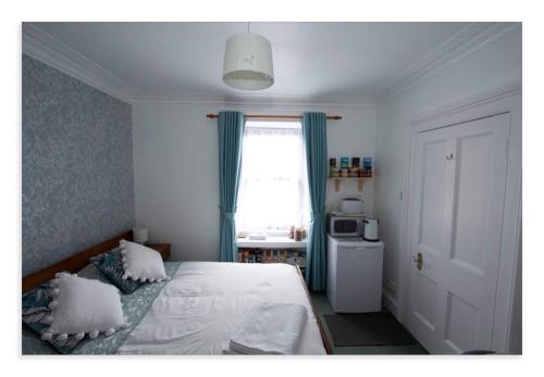 a bedroom with a bed with pillows and a window at Cornmill House, With Outstanding Sea Views In Garlieston in Garlieston