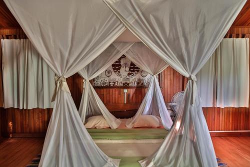 a bedroom with a canopy bed with mosquito nets at KIMONY RESORT in Morondava