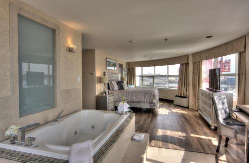 a bath room with a large tub and a large window at The Lonsdale Quay Hotel in North Vancouver