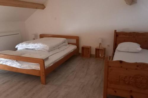 1 dormitorio con 2 camas y suelo de madera en Petit gîte rural - la Forge -, en Sainte-Marie-sur-Ouche