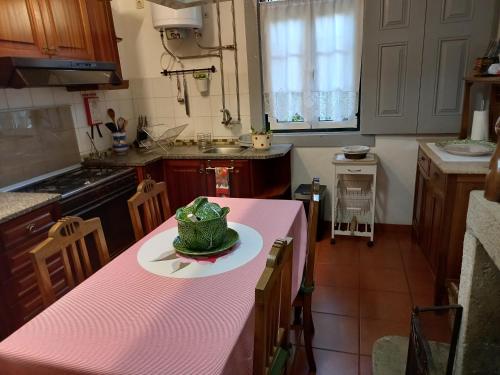 a kitchen with a pink table with a cake on it at Quinta Casa Do Quintal in Lamego