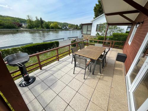 a patio with a table and chairs and a grill at Chalet de l'écluse in Namur