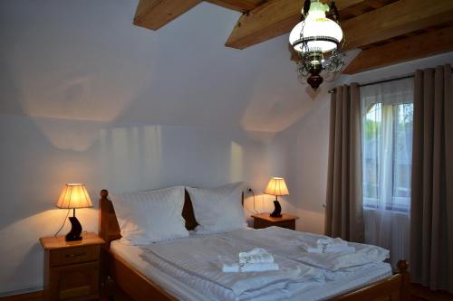 a bedroom with a bed with two lamps and a window at Casa Traditionala Breb in Breb