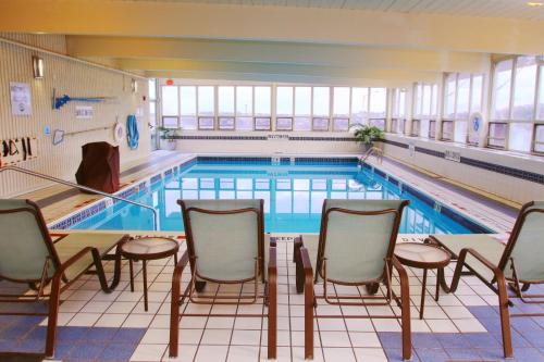 a large swimming pool with chairs and tables in front of it at Holiday Inn Express Pittsburgh West - Greentree, an IHG Hotel in Pittsburgh