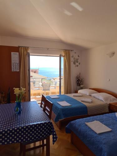 a hotel room with two beds and a balcony at Apartmani Katarina in Makarska
