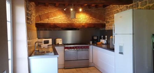 uma cozinha com electrodomésticos brancos e um frigorífico branco em Gite Le Morvan em Lormes
