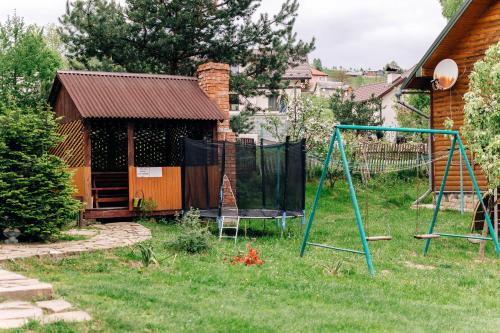 einen Hof mit einer Schaukel und einem Haus in der Unterkunft Котедж з неймовірними краєвидами in Slawske
