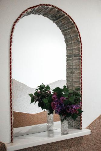 a vase with flowers on a shelf in front of a mirror at Котедж з неймовірними краєвидами, Карпатський Чан DREAM, Чан Джакузі in Slavske