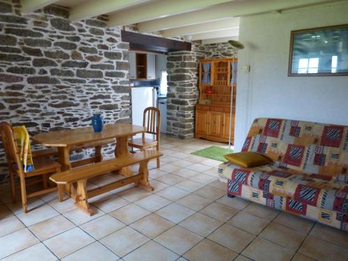 uma sala de estar com uma mesa e uma parede de pedra em GITE DE CARACTERE em Lopérec