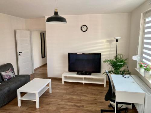 uma sala de estar com uma televisão de ecrã plano na parede em Apartament Łagiewniki na Cracóvia