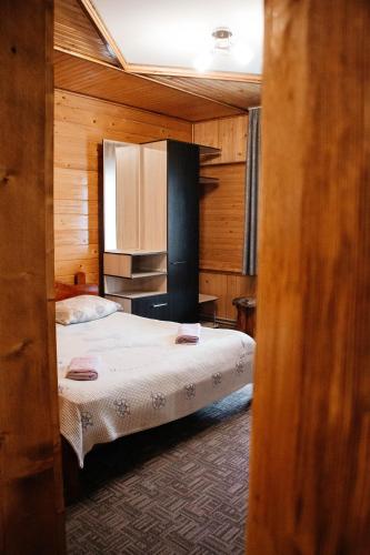a bedroom with two beds in a wooden room at Котедж з неймовірними краєвидами, Карпатський Чан DREAM, Чан Джакузі in Slavske