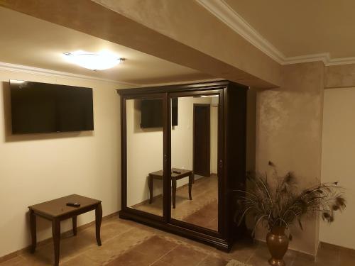 a room with a mirror and a tv and a table at CASA LUCA in Moldova Nouă