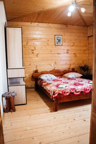 a bedroom with a bed in a wooden room at Котедж з неймовірними краєвидами, Карпатський Чан DREAM, Чан Джакузі in Slavske