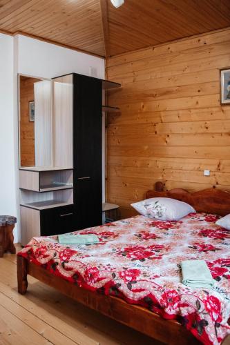 a bedroom with a large bed with a wooden wall at Котедж з неймовірними краєвидами, Карпатський Чан DREAM, Чан Джакузі in Slavske