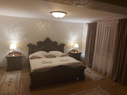 a bedroom with a large bed with two lamps at CASA LUCA in Moldova Nouă