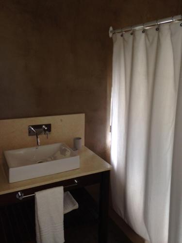 a bathroom with a sink and a shower curtain at CASA HORTENSIAS in Quequén