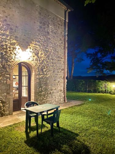 a table and a bench in front of a building at Agriturismo L'Antica Quercia in Pomarance