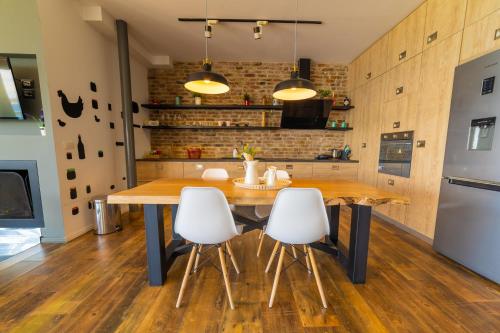 a kitchen with a wooden table and white chairs at Epirus Hotel in Sarandë