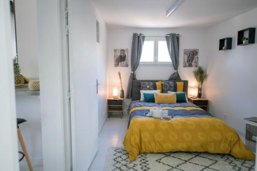 a bedroom with a yellow bed and a window at Le Charmant Pontault Combault in Pontault-Combault