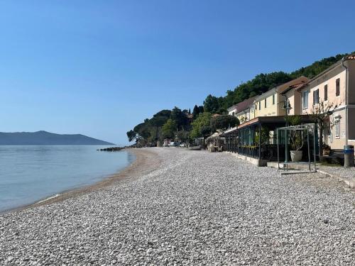 una playa rocosa con casas y agua en BISER KVARNERA 2, en Mošćenička Draga