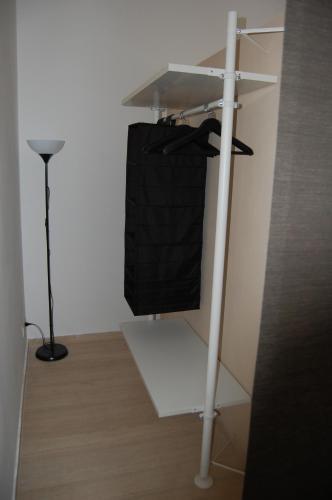 a white shelf with a black bag on it at Arena Alfieri B&B in Livorno