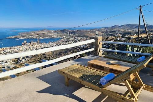 a picnic table on a balcony with a view of the city at Κατοικία Uppolis με θέα τα νησιά in Ano Syros
