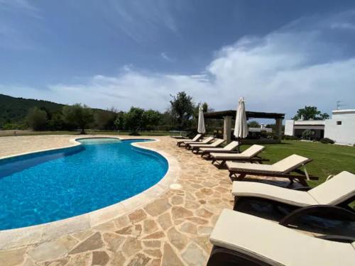 a pool with chaise lounge chairs and a resort at CAN FARITZEO in Sant Rafael de Sa Creu