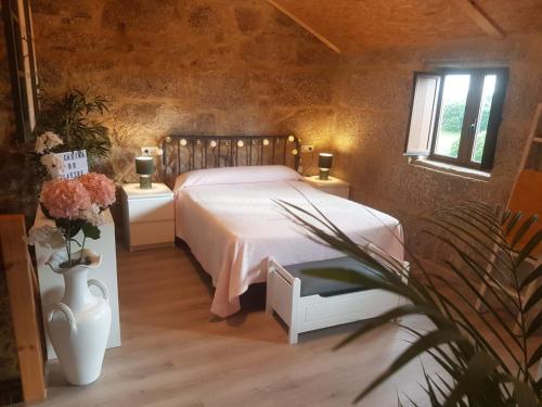 a bedroom with a white bed and two windows at A Casiña do Xastre in Pontevedra