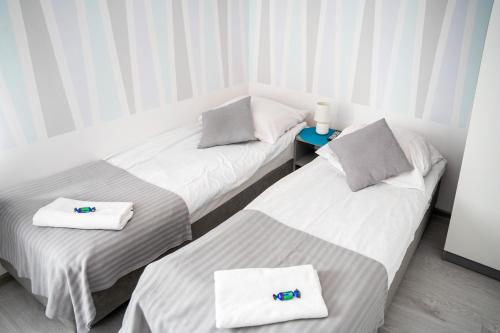 two beds in a hotel room with towels on them at Marinas Rewa in Rewa