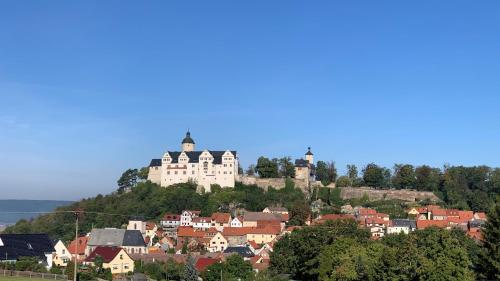 a town with a castle on top of a hill at Café Ilse - Ferienwohnungen in Ranis